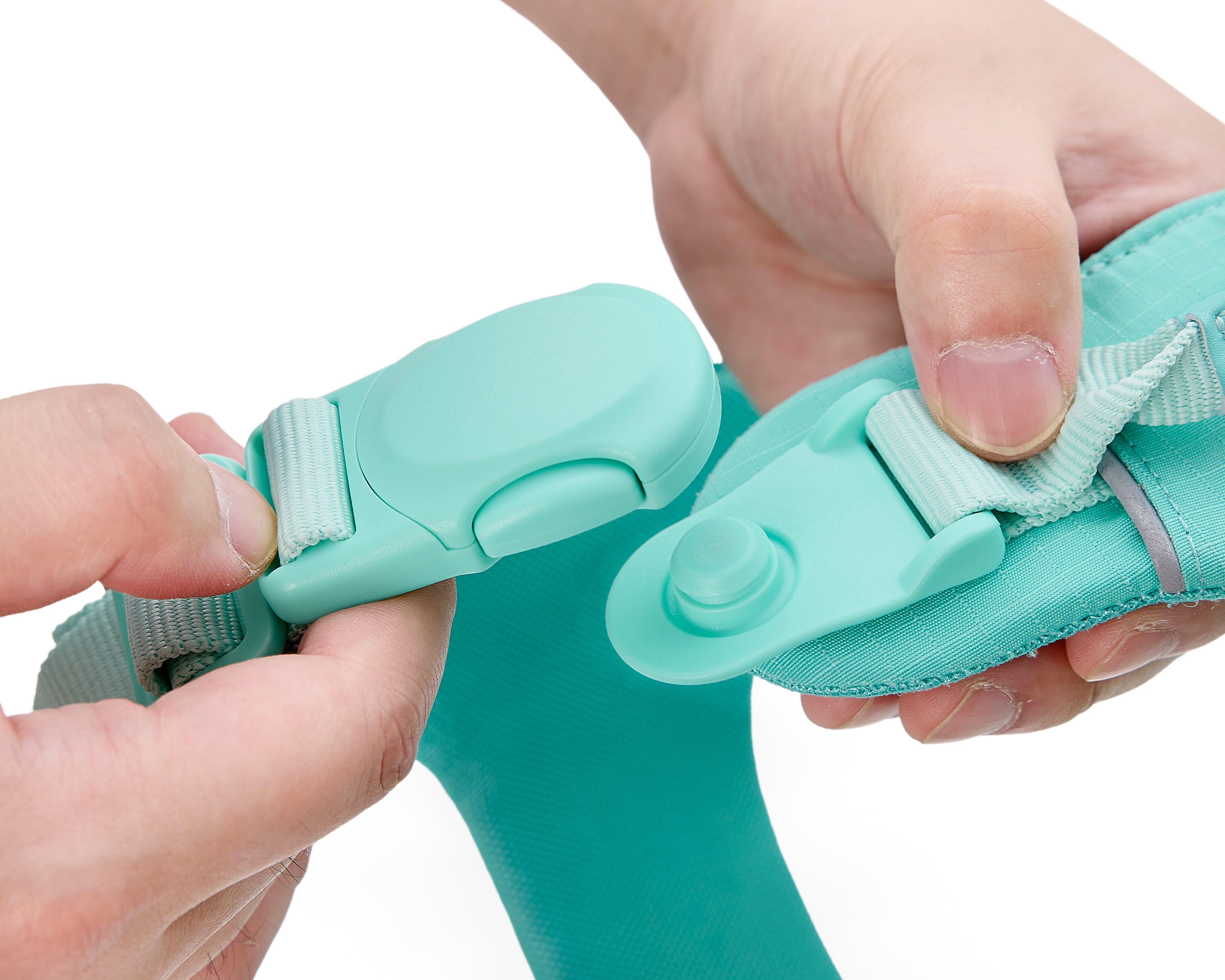 Hands operating quick-release magnetic buckle on Soul and Tail Mint Green dog harness