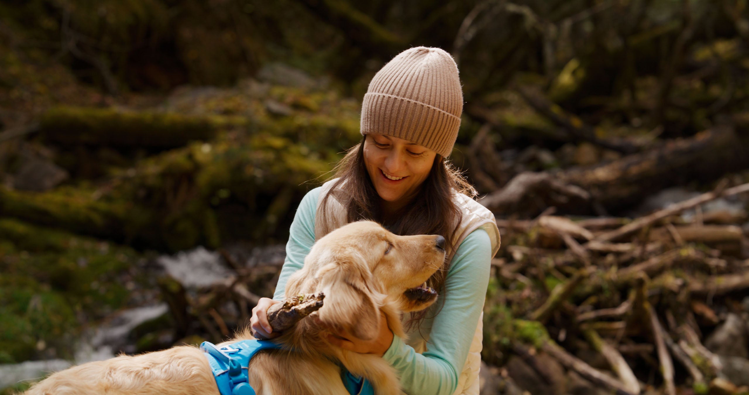 Woman sitting with a dog in a natural setting