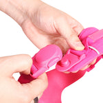 Close-up of hands adjusting a pink plastic magnetic buckle on a white background