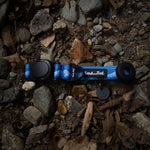 A blue dog collar with black magnetic buckle on a rocky ground
